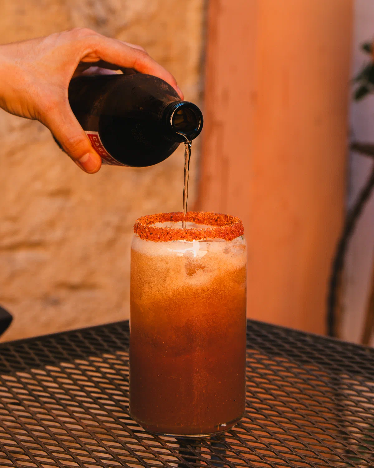Cerveza servida sobre un vaso escarchado con chile en la cafetería Audaz