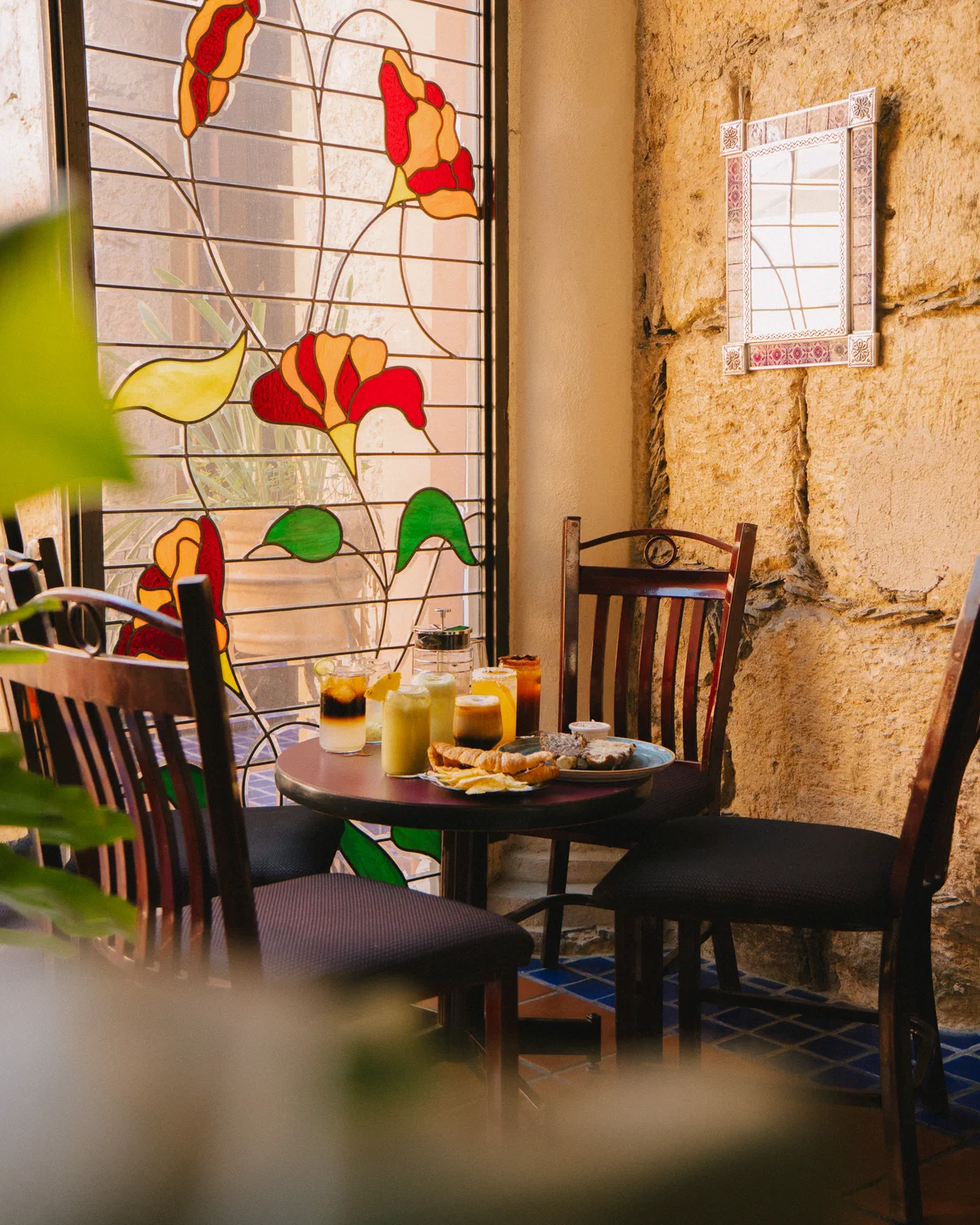 Mesa con bebidas junto al vitral de flores en la cafetería Audaz