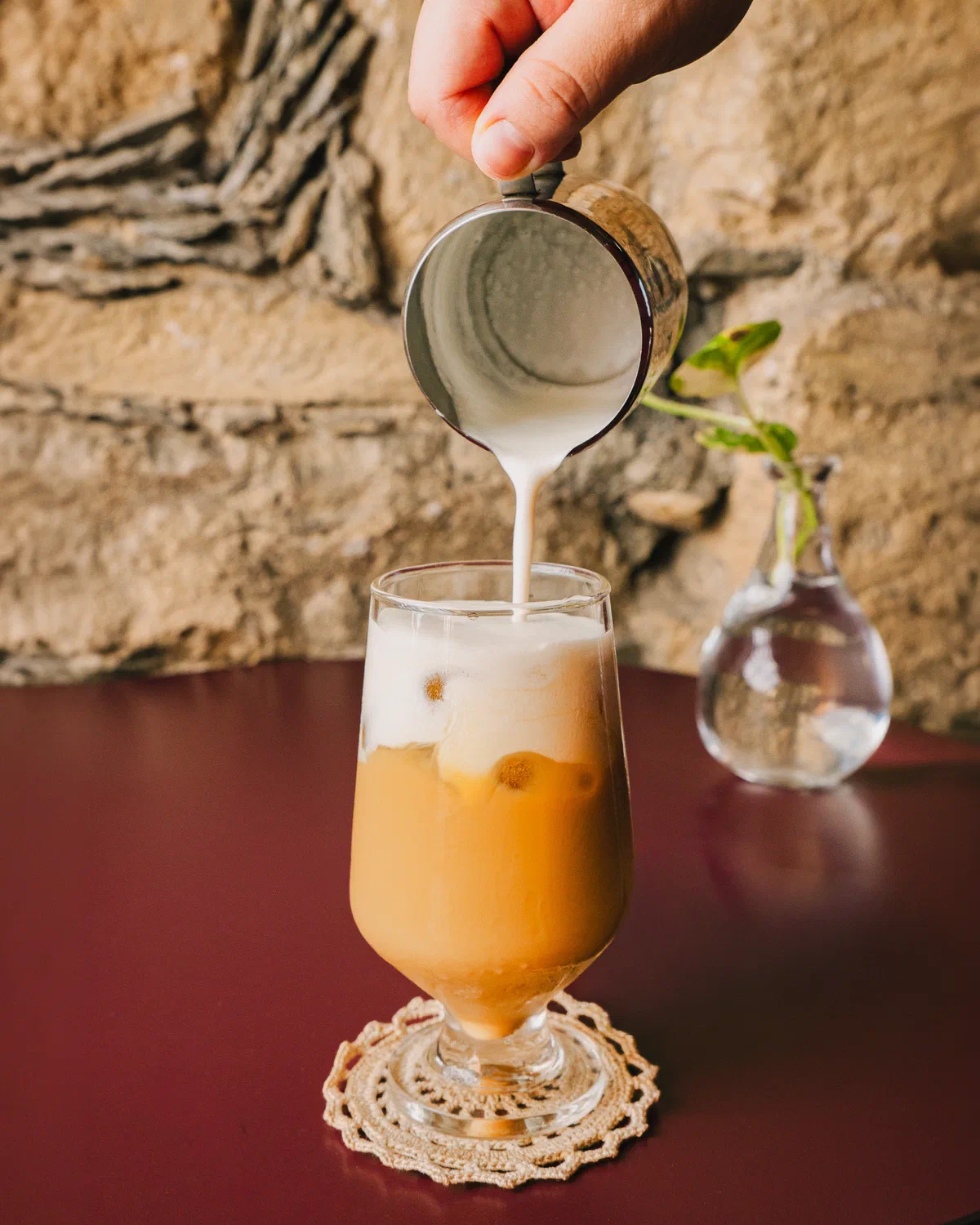Leche vertida sobre un café helado en copa de vidrio