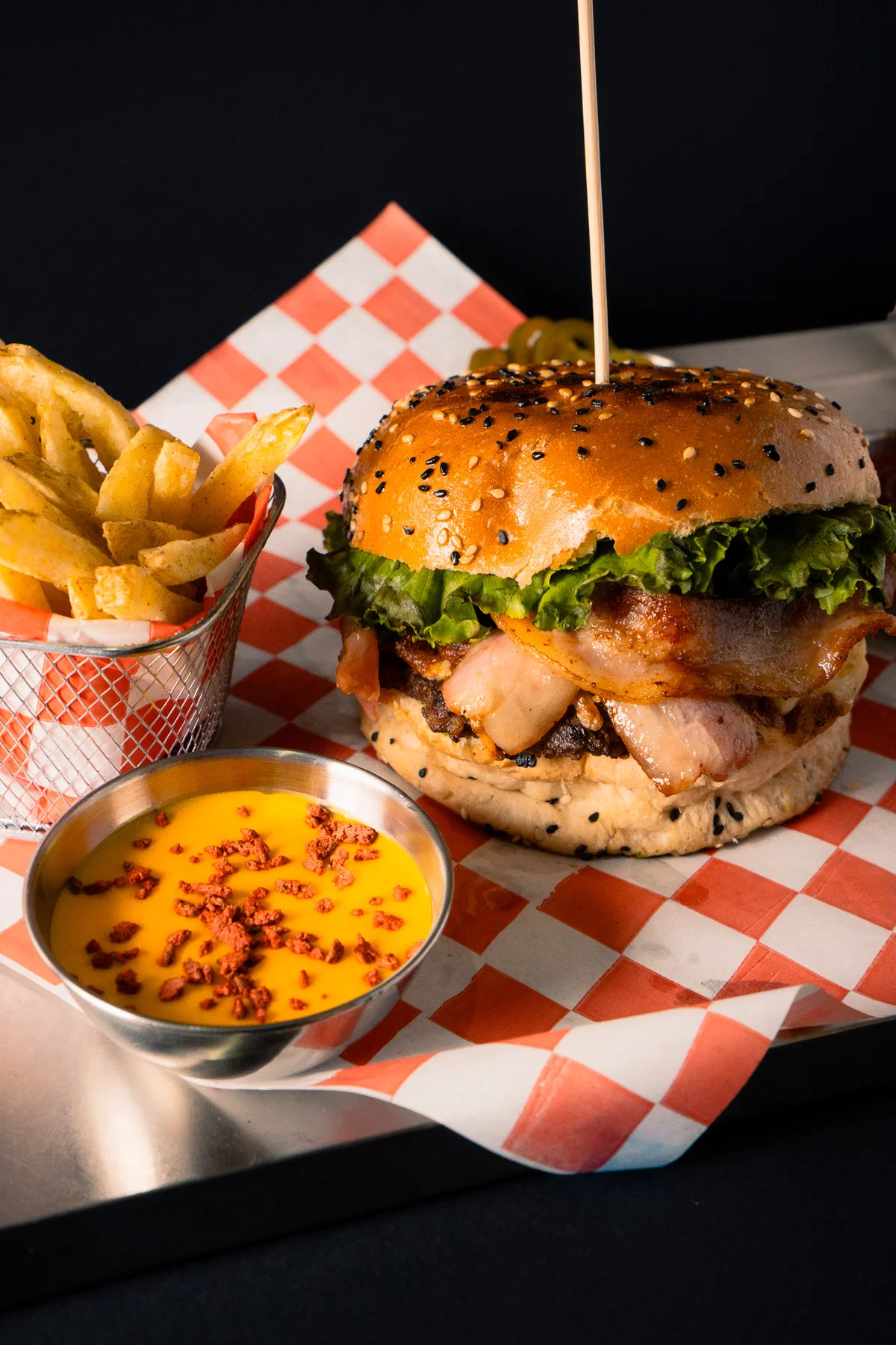 Hamburguesa con tocino, papas fritas y salsa de queso con tocino