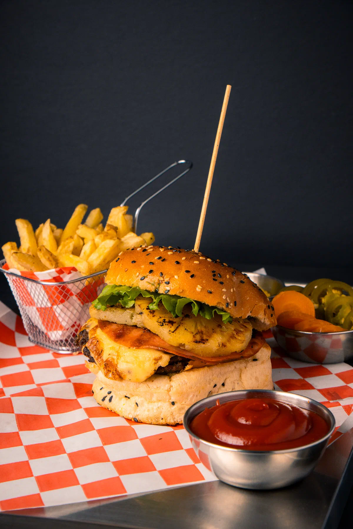 Hamburguesa con piña asada y queso, papas fritas y catsup