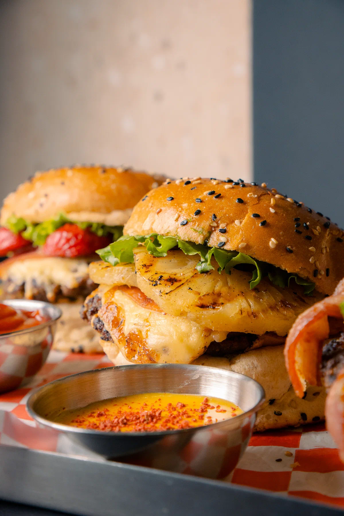 Hamburguesas con piña asada y pimiento junto a salsa de queso
