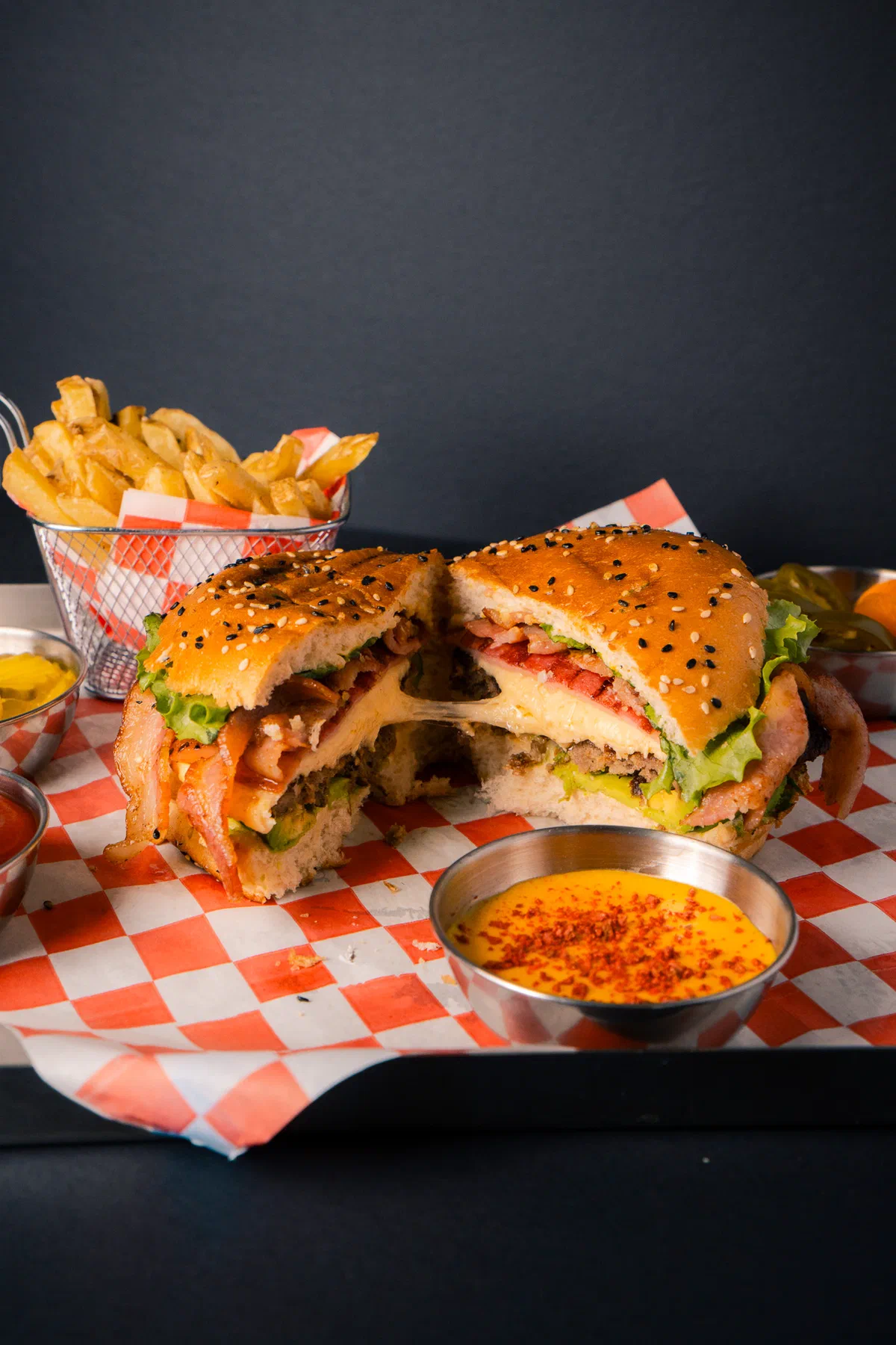 Hamburguesa partida a la mitad con queso derretido y tocino