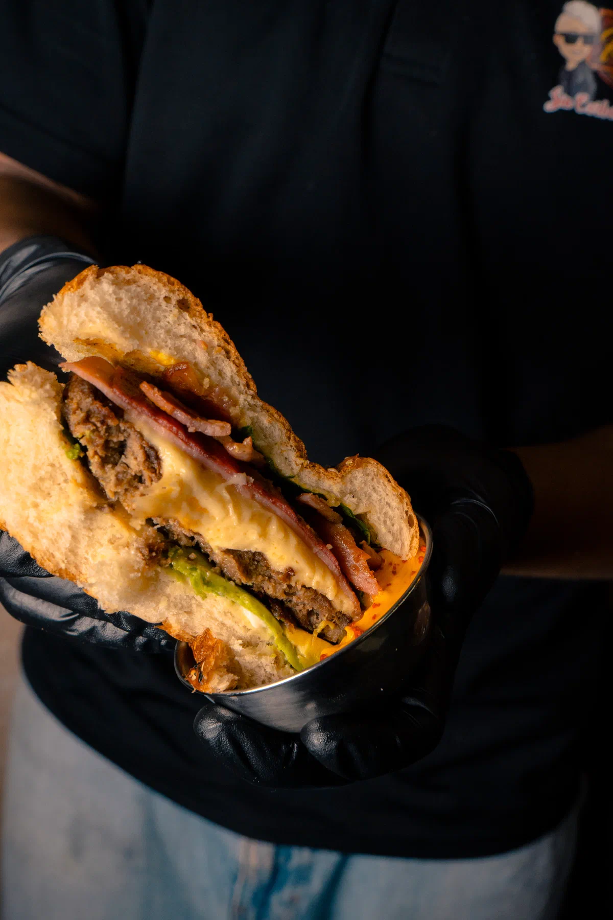 Mitad de hamburguesa con tocino y queso sobre recipiente metálico
