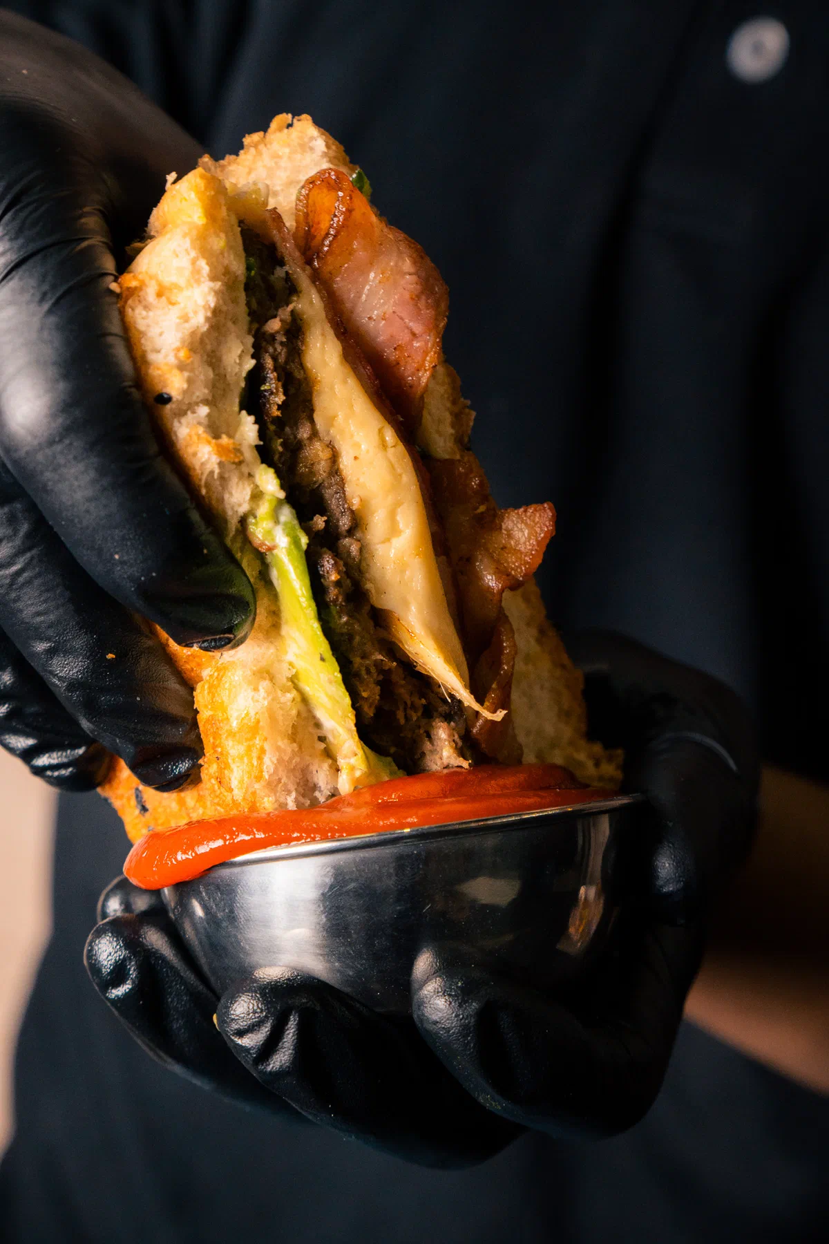 Hamburguesa con tocino sumergida en salsa